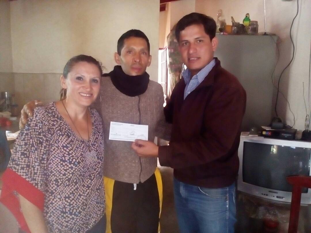 Luis Toro beneficiario de una ayuda económica en compañia de representantes del ejecutivo regional