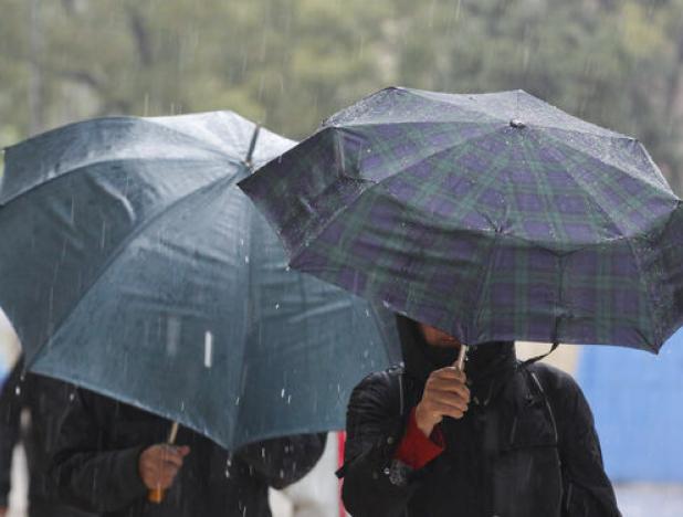 personas-pasean-lluvia-protegidos-paraguas_1390971053_105994847_667x375